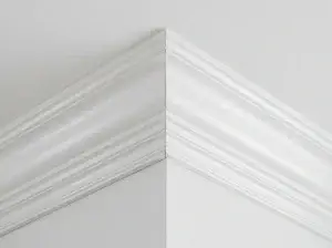 Close-up of mitred crown molding corner joint finished flush against the wall