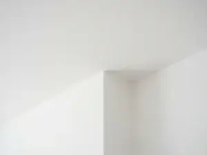 Close-up of a scraper removing popcorn texture from a drywall ceiling
