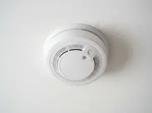 Close-up of a smoke detector being twisted onto its base plate