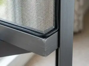 Close-up of spline securing fresh mesh in a window screen frame