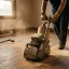 Handyman sanding a hardwood floor with an orbital floor sander