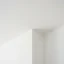 Close-up of a scraper removing popcorn texture from a drywall ceiling