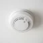 Close-up of a smoke detector being twisted onto its base plate