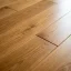 Close-up of a screw fastening floorboards to stop a squeak