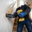 Handyman fastening a wooden stair railing post to the staircase