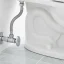 Close-up of a toilet base sealed with a wax ring and bolts